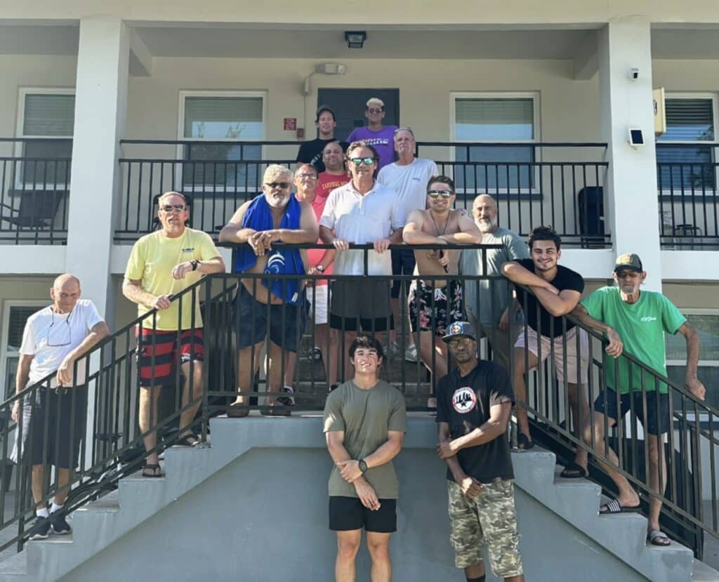group of men on balcony stairs at a sober living social event